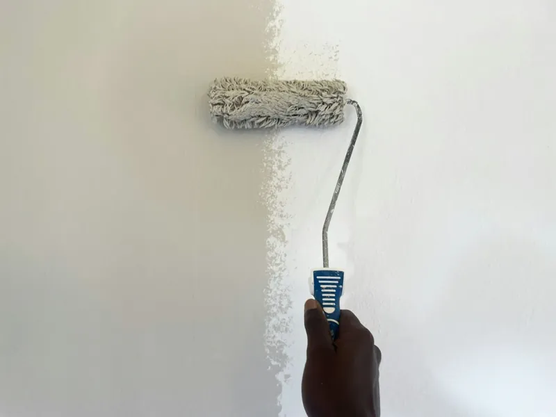 Paint roller applying fresh paint to an interior wall